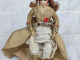 a doll that is sitting on a white surface