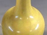 a yellow vase that is sitting on a table