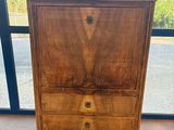 une commode en bois devant une grande fenêtre