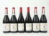six bouteilles de vin sont alignées sur une surface blanche