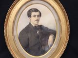an old picture of a man in a suit and tie sitting in front of a black background