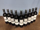 several bottles of wine are lined up on a wooden table