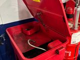 a red fire hydrant sitting on a cart in a garage