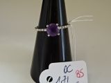 une bague ornée d'une fleur violette et à laquelle est attachée une étiquette de prix