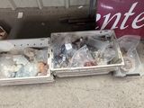 two bins filled with assorted items sitting on the ground