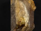 un gros plan d'un morceau de quartz jaune sur fond noir