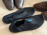 several pairs of shoes are lined up on a tile floor