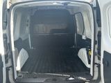 une camionnette blanche dont la porte est ouverte, garée sur un parking