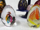 five glass egg shaped vases sitting next to each other