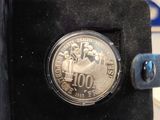 someone is holding a coin in their hand in a black box