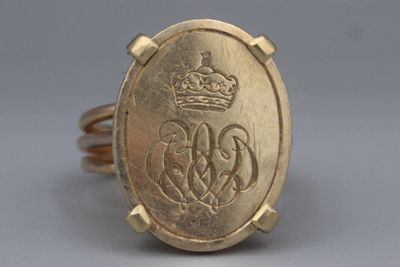 une image représentant une bague en or surmontée d'une couronne