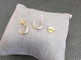 une paire de boucles d'oreilles en or posée sur un oreiller