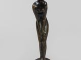 une statue de bronze représentant une femme debout sur un piédestal