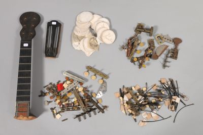 plein de vis, des vis, et une guitare posée sur une table
