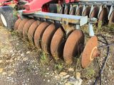 a tractor that is sitting in the dirt near a field