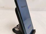 a close up of a cell phone on a stand on a white surface