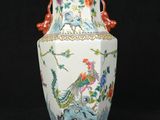 a vase with a bird and flowers on it on a black background