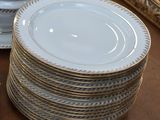 many plates and bowls on the table with a mirror in the background