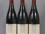 three bottles of red wine are lined up on a table