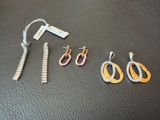 three pairs of earrings and a pair of scissors on a table