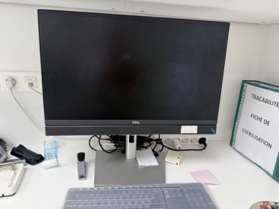 a computer monitor sitting on a desk with a keyboard and mouse