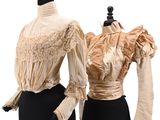 two mannequins with dresses on display on a white background