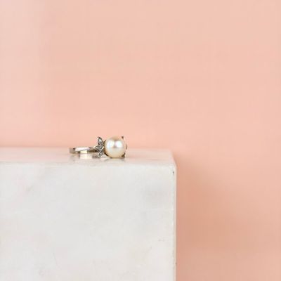 une bague de fiançailles posée sur un bloc de marbre blanc