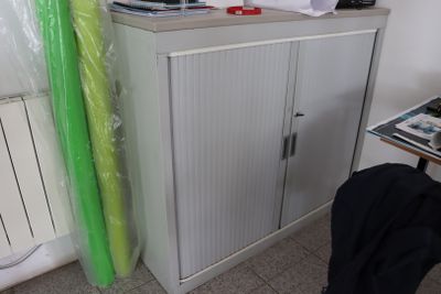 une armoire blanche surmontée d'un rideau vert