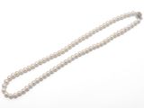un collier à un rang de perles blanches avec un fermoir en argent
