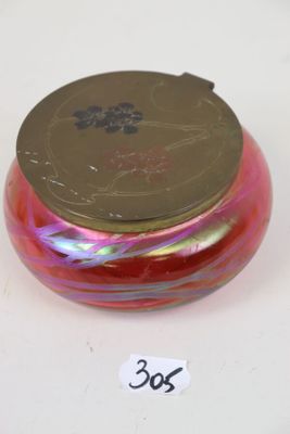 un bol en verre rouge et rose avec un couvercle doré