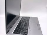a silver laptop with a black keyboard on a white surface