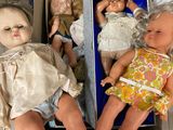 three dolls sitting in a box on the floor