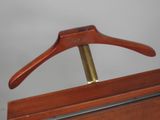 a wooden hanger with a brass bar on it