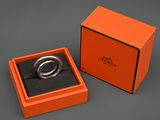 une boîte orange contenant une bague, posée sur une table