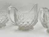 trois pichets en verre transparent posés sur une table blanche