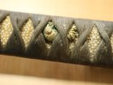 a close up picture of a sword with a lizard on it ' s blade