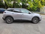 a silver suv parked in a parking lot next to trees