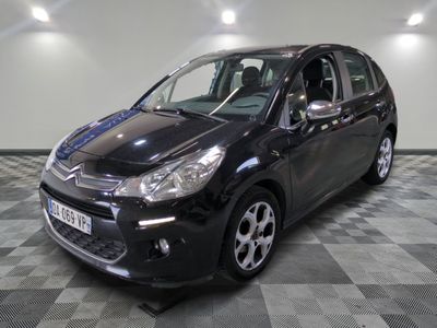 la petite voiture noire est garée sur un sol en damier