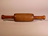 a wooden rolling pin with a wooden handle on a white surface