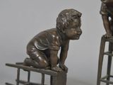 a statue of a boy sitting on a stool next to a statue of a dog