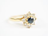 un gros plan d'une bague en or sertie d'un saphir bleu et de diamants blancs