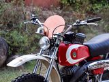 a red and white dirt bike parked on the side of the road