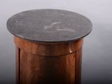 a round table with a marble top on a gray background