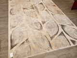 beige and white area rug with leaves on it in a room