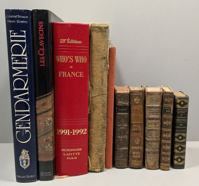 several old books are lined up on a shelf in front of a white wall