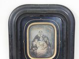 une vieille photo d'une femme tenant un bébé dans un cadre noir
