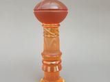 un bougeoir en verre orange sur fond blanc