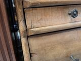 a wooden dresser with three drawers and a drawer underneath it