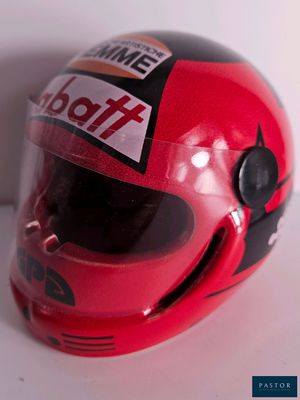 un casque rouge orné d'un autocollant, posé sur une table