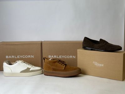 three pairs of shoes sitting on top of boxes next to each other